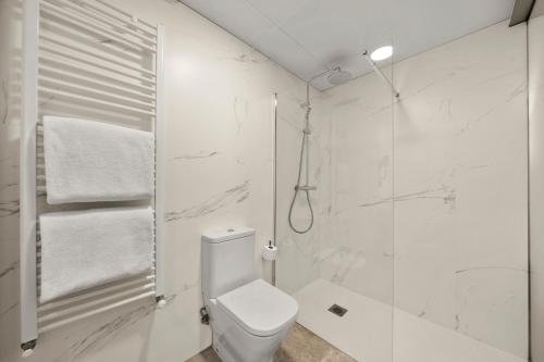 a white bathroom with a toilet and a shower at Hotel Zentral Ramiro I Oviedo in Oviedo