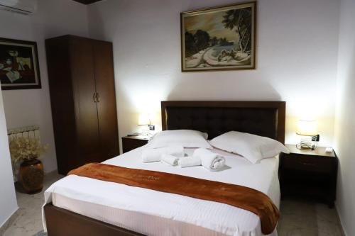 a bedroom with a large bed with two towels on it at Villa Palma Center in Berat