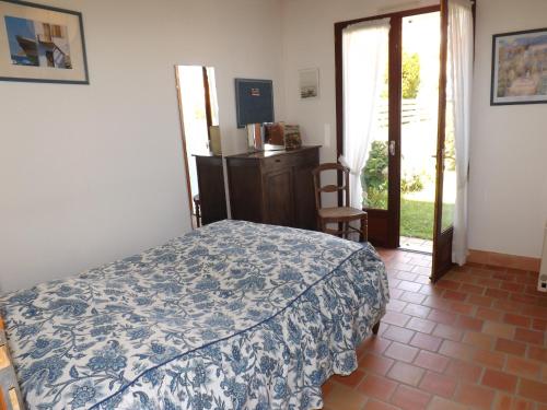 une chambre avec un lit avec une couverture bleue et blanche dans l'établissement Maison 3 chambre quartier Boisvinet, à Saint-Gilles-Croix-de-Vie