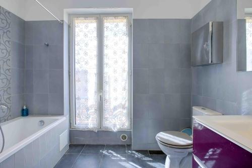 La salle de bains est pourvue de toilettes, d'une baignoire et d'une fenêtre. dans l'établissement Maison Bianchi - 27 Lepante, à Nice