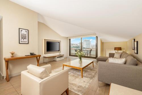 a living room with a couch and a tv at Tzl Suites Hotel Nişantaşı in Istanbul