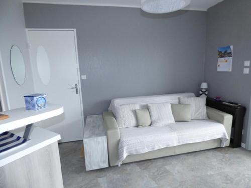 - un salon avec un canapé blanc dans l'établissement Le Chenal, à Saint-Gilles-Croix-de-Vie