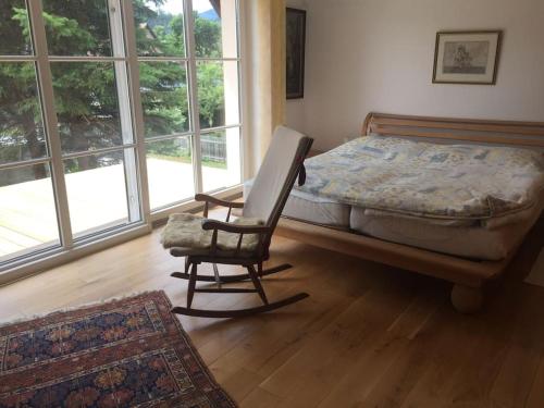 Un dormitorio con una cama y una silla en una habitación. en living like at your own home, en Reichenau