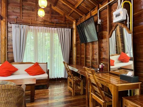 a dining room with a table and a desk with a mirror at บ้านสวนแก้วคำแพง Baan Suan Kaew Khampaeng in Udon Thani