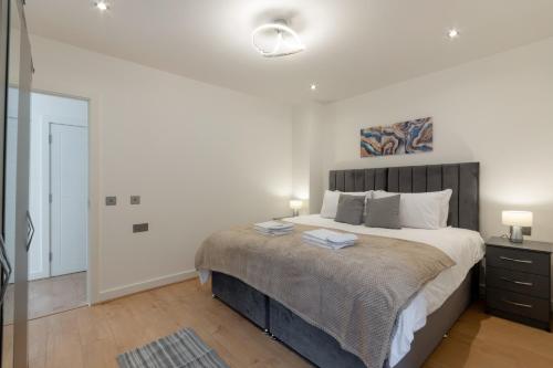 a bedroom with a large bed in a white room at Modern Two Bedrooms Flat in Julien Road, CR5, London in Coulsdon