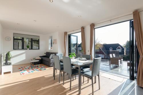 a dining room and living room with a table and chairs at Modern Two Bedrooms Flat in Julien Road, CR5, London in Coulsdon