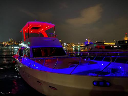 a white boat with blue lights on the water at night at ESESYATTURİZM in Istanbul