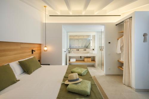 a bedroom with a bed with a hat on it at Fincahotel Treurer - Olive Grove & Grand House - Adults Only in Algaida