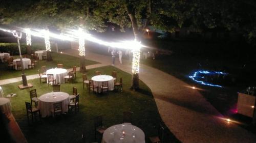 a group of tables with lights in a park at night at VillaGrancassa Hotel Relais in San Donato Val di Comino