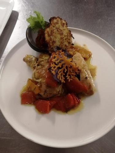 a white plate of food with meat and vegetables at VillaGrancassa Hotel Relais in San Donato Val di Comino