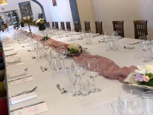 a long table with wine glasses and flowers on it at VillaGrancassa Hotel Relais in San Donato Val di Comino