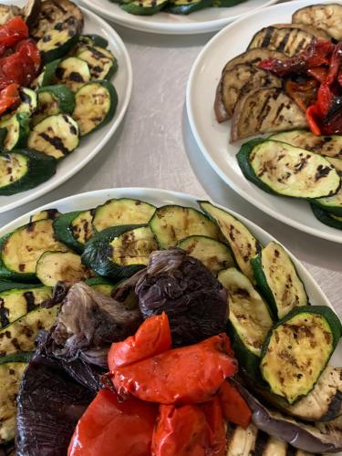 a table topped with plates of food with peppers and vegetables at VillaGrancassa Hotel Relais in San Donato Val di Comino