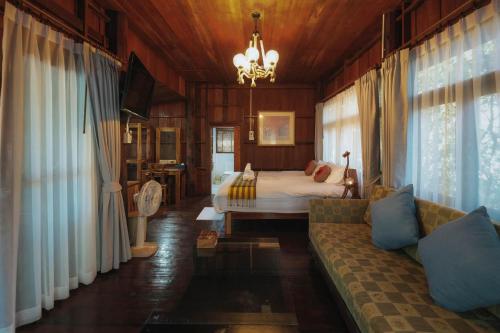 a living room with a bed and a couch at บ้านสวนแก้วคำแพง Baan Suan Kaew Khampaeng in Udon Thani