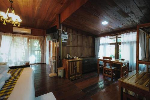 a bedroom with wooden walls and a wooden floor at บ้านสวนแก้วคำแพง Baan Suan Kaew Khampaeng in Udon Thani
