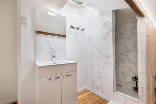 une salle de bain blanche avec une douche et un lavabo dans l'établissement Home Sweet Home Arc de Triomphe Villa Laugier, à Paris