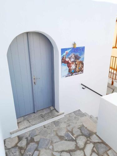 a blue door in a white room with a painting at ZEUS HOUSE in Symi