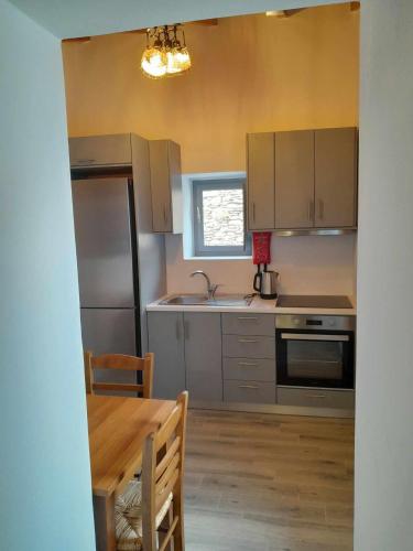 a kitchen with stainless steel appliances and a table at "Zeus House" Sevasti Symi Studios in Symi