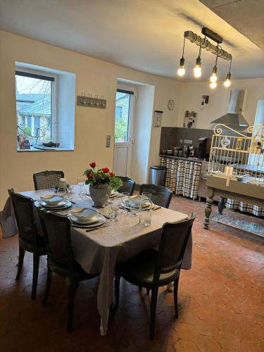 a dining room with a table and chairs and a kitchen at Gite le Patis in Pré-en-Pail
