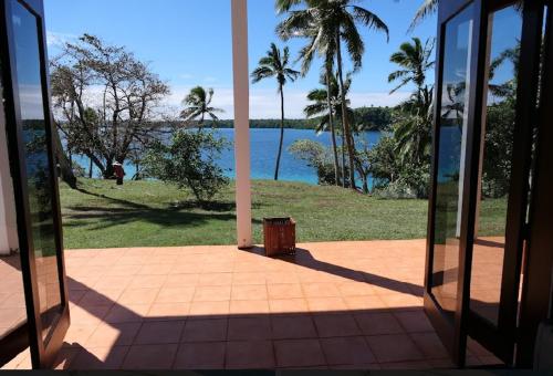Zimmer mit Blick auf das Wasser und die Palmen in der Unterkunft Saralee’s House in Toula