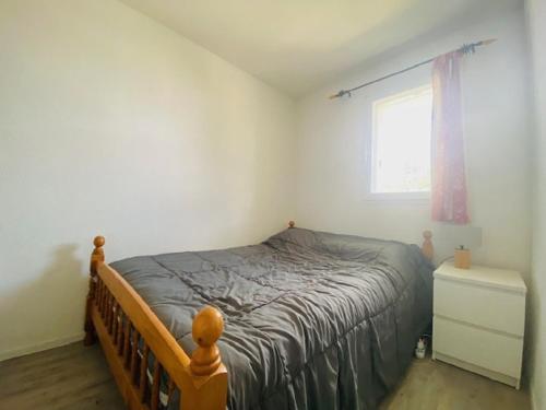 une chambre avec un lit et une fenêtre dans l'établissement L'Ancre, à Saint-Gilles-Croix-de-Vie