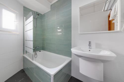 un bagno bianco con lavandino e vasca di Hotel Madrid a Torrevieja