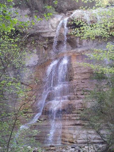 a waterfall on the side of a rock cliff at Le Saint Vincent in Apremont