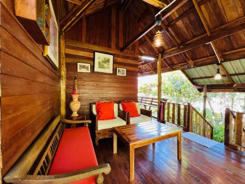 a porch of a wooden house with a table and chairs at บ้านสวนแก้วคำแพง Baan Suan Kaew Khampaeng in Udon Thani