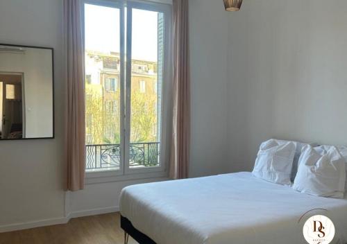 a bedroom with a bed and a large window at Havre de paix spacieux près du Prado et du Stade Vélodrome in Marseille