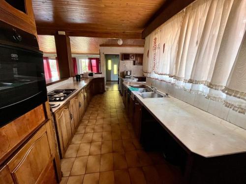 cocina grande con armarios y encimeras de madera en Kharimbi Camp House, en Brakpan