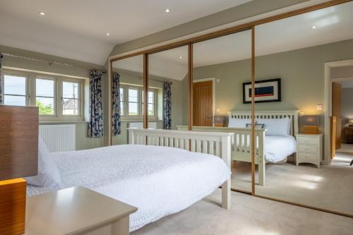 バーナム・マーケットにあるGuardian Houseのベッド2台と大きな鏡のある寝室