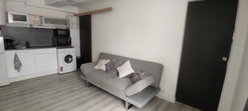 a living room with a couch and a kitchen at Superbe appartement en plein centre ville in Viarmes