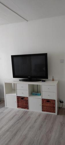 a white entertainment center with a flat screen tv on it at Superbe appartement en plein centre ville in Viarmes