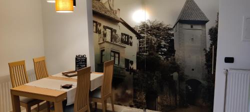 a table and chairs in a room with a painting on the wall at Suite - Sweet MayLeen in Merano