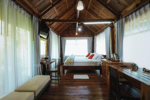 a bedroom with a bed and a desk in a room at บ้านสวนแก้วคำแพง Baan Suan Kaew Khampaeng in Udon Thani