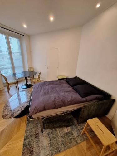 une chambre avec un grand lit et une table dans l'établissement Appartement 35 m² dans le Marais, à Paris