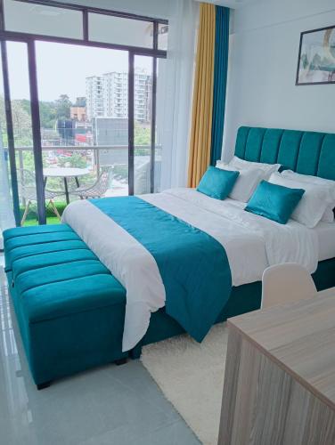 a bedroom with a large bed and a blue couch at Wanderstay kenya in Nairobi