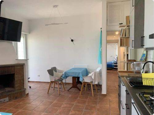een keuken met een tafel en stoelen in een kamer bij Sole Vista Mare 999 in LʼAmericano