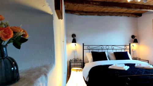 a bedroom with a bed with a vase of flowers at Casa Lina (Unesco zone) in Segusino