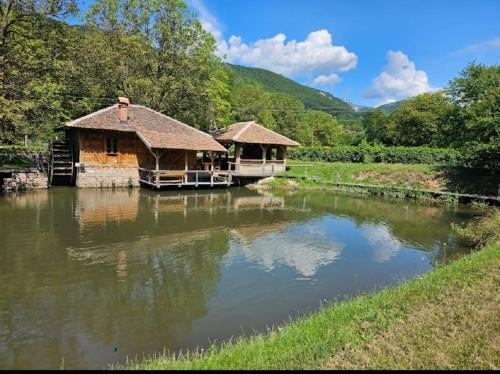 a house on the water next to a river at Vodenica Lug in Strmosten