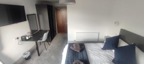 een slaapkamer met een bed met blauwe kussens en een televisie bij John Eoinìn's Bar and accommodation in Glencolumbkille