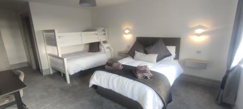 um quarto de hotel com duas camas e uma cadeira em John Eoinìn's Bar and accommodation em Glencolumbkille
