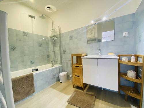 Un baño con lavabo, bañera y ducha. en L'Aigue Marine, en Saint Gilles Croix de vie
