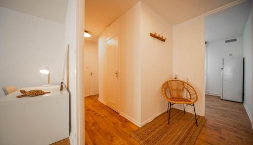 Cette chambre comprend une chaise et un lit. dans l'établissement Le Balinais - Appartement à Chalon-sur-Saône, à Chalon-sur-Saône