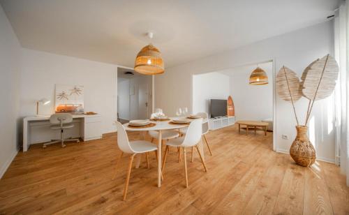 une salle à manger avec une table et des chaises blanches dans l'établissement Le Balinais - Appartement à Chalon-sur-Saône, à Chalon-sur-Saône