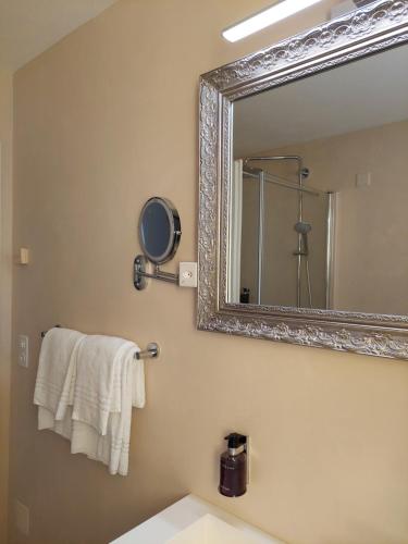 a bathroom with a mirror and a sink at Dolceresio Lugano Lake B&B in Brusino Arsizio