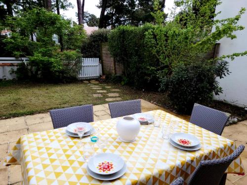 une table jaune et blanche avec un vase dessus dans l'établissement La Capeline, à Saint-Jean-de-Monts