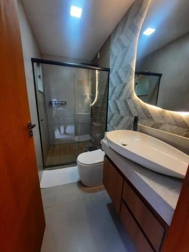 a bathroom with a shower and a toilet and a sink at Chalé Mury in Nova Friburgo