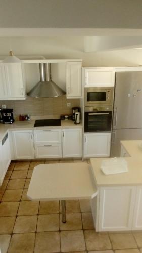 a kitchen with white cabinets and a stove top oven at PRINCESS OF BLUE EAGLES RETREAT in Skaloma