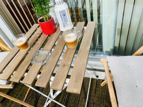 a picnic table with two glasses of beer on it at North Greenwhich Homestay in London