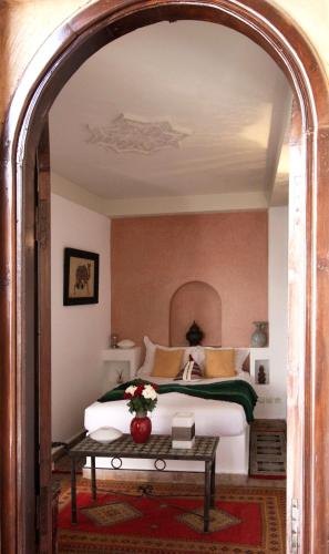 an archway leading into a bedroom with a bed at Riad Palmier in Marrakech